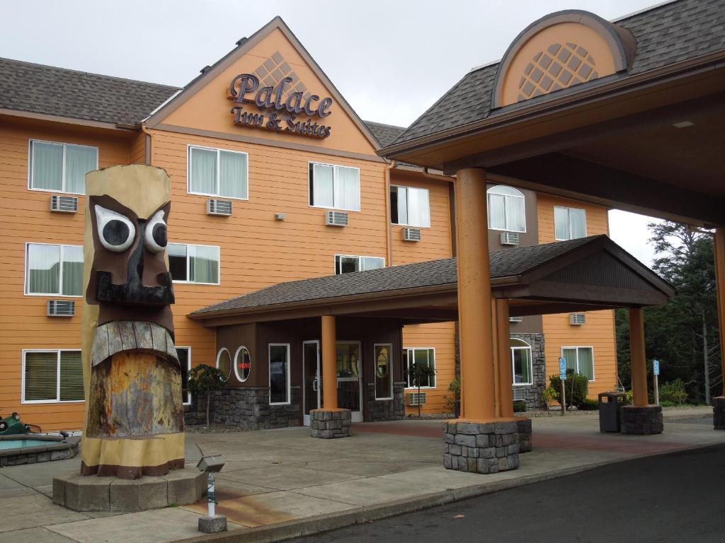 a hotel with a large building with a owl sign at Palace Inn & Suites in Lincoln City