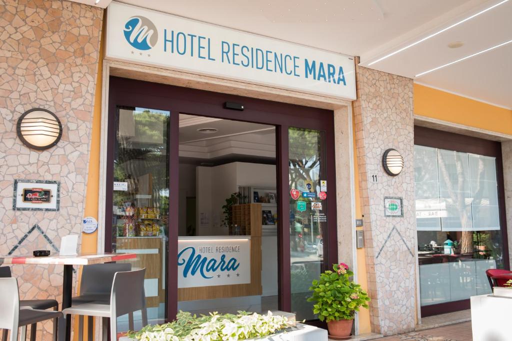 un restaurant d'hôtel avec un panneau à l'avant dans l'établissement Hotel Residence Mara, à Lido di Jesolo