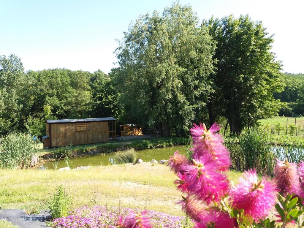d'un jardin avec une cabine en arrière-plan ornée de fleurs dans l'établissement Les roulottes de Cambonis, à Bourret