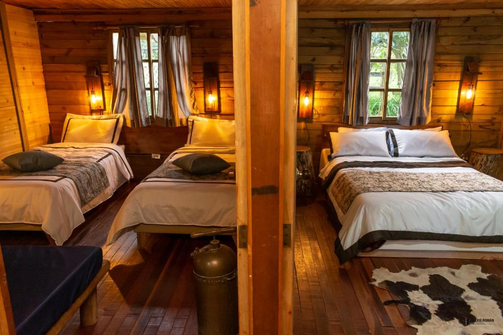 um quarto com 2 camas num chalé de madeira em Palmas de Cocora em Salento