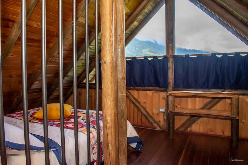 a bed in a wooden room with a window at Palmas de Cocora in Salento