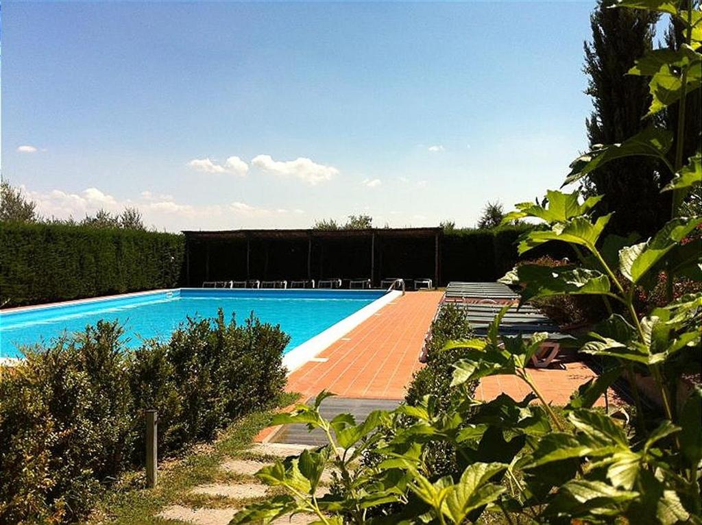 a swimming pool in a garden with bushes at Bilocale Agriturismo in Pistoia