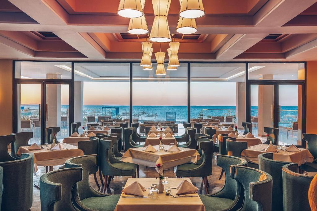 a restaurant with tables and chairs and a view of the ocean at Iberostar Selection Kuriat Palace in Monastir