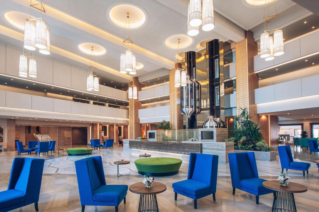 a lobby of a hospital with blue chairs and tables at Iberostar Selection Kuriat Palace in Monastir