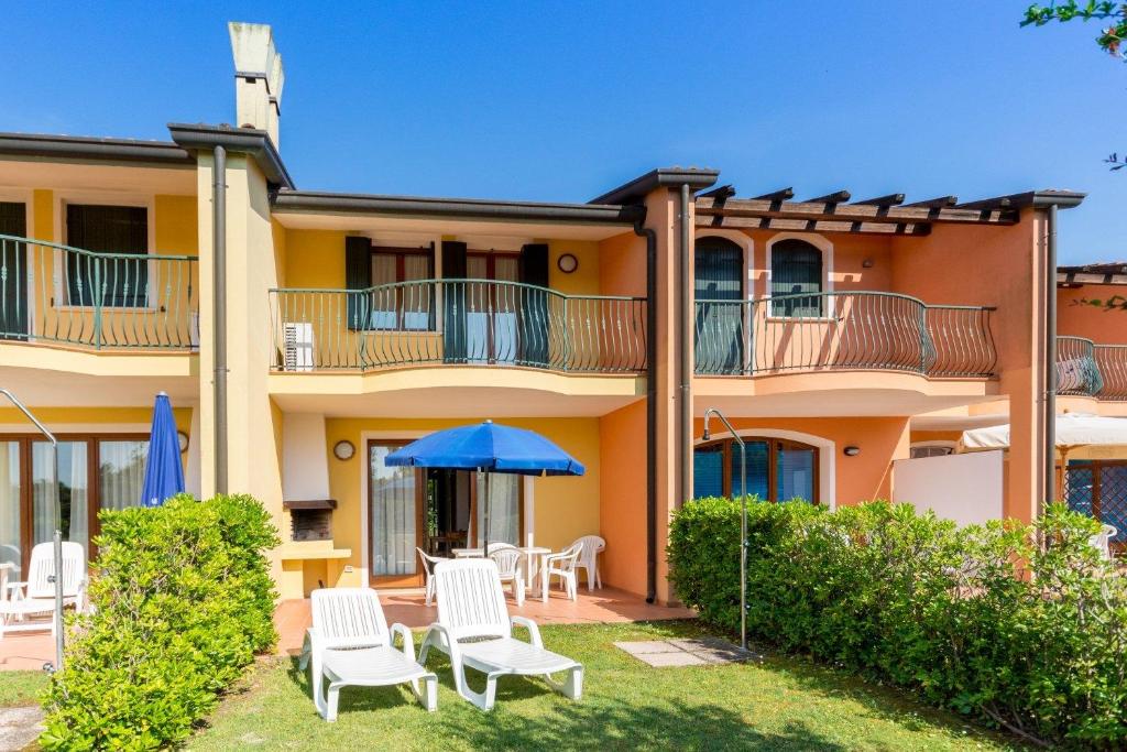 un immeuble avec des chaises et un parasol dans l'établissement Bungalow S3, à Albarella