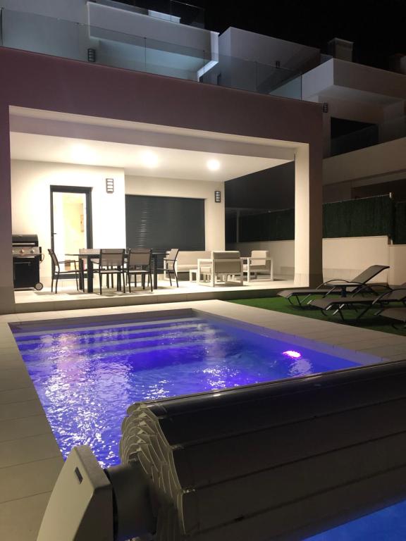 a swimming pool in a house with a dining room at Villa Deluxe La Marina Beach in Alicante