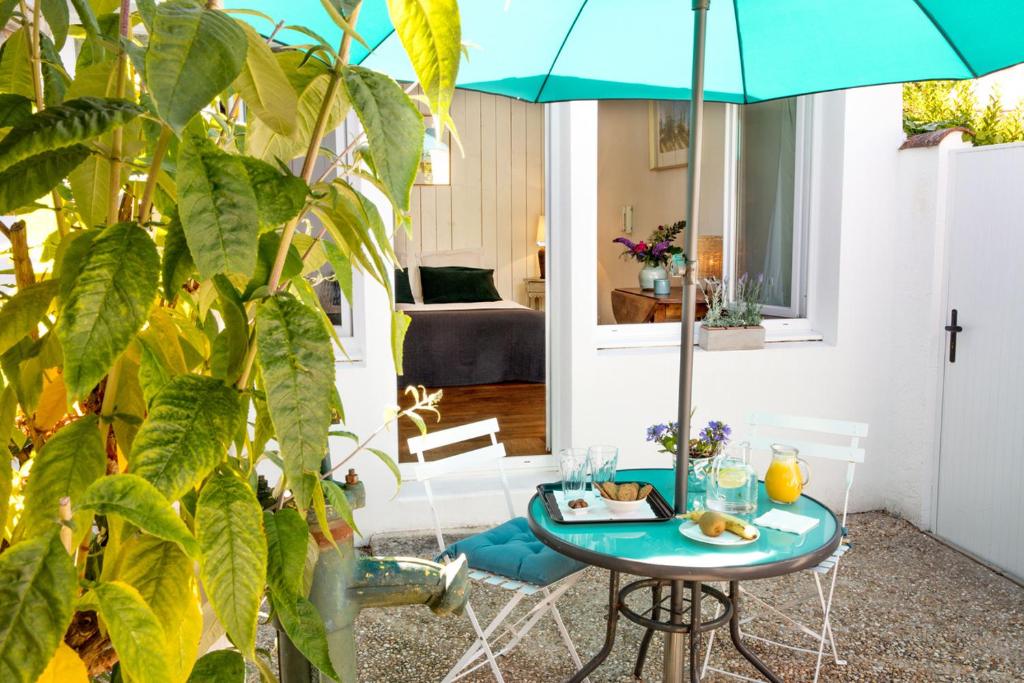 ein Zimmer mit einem Tisch und einem Sonnenschirm in der Unterkunft La Venelle de Jéricho in La Rochelle