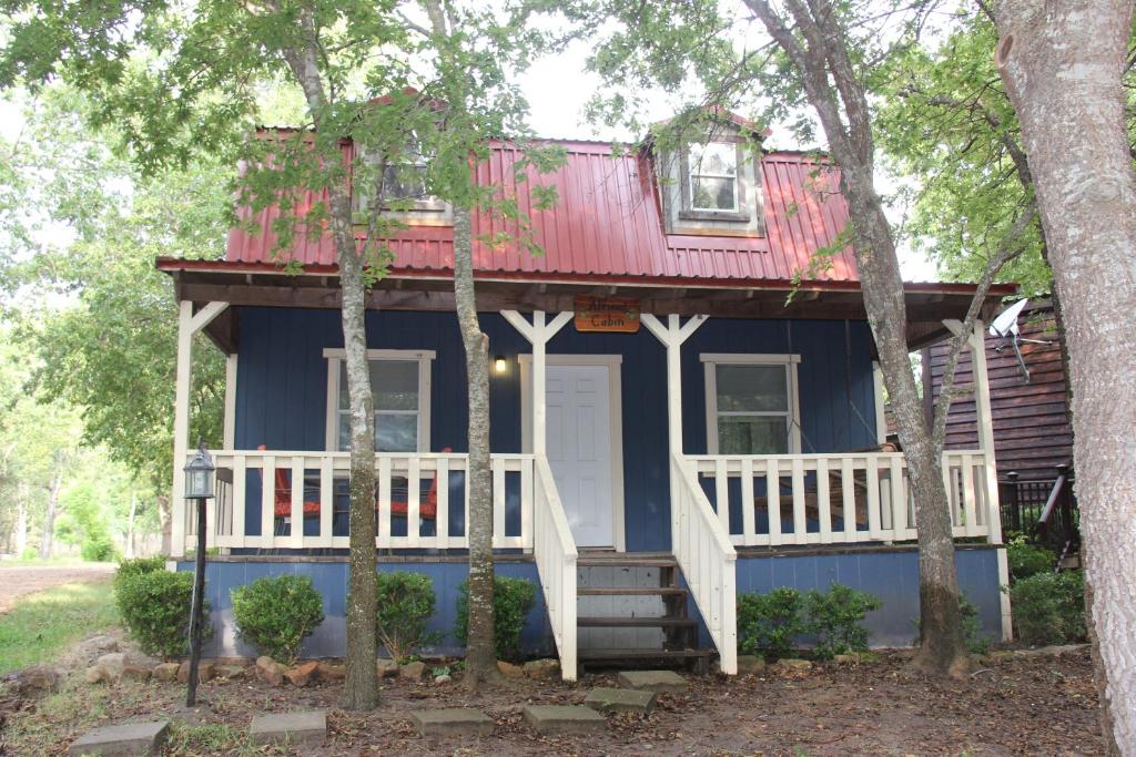 uma casa azul e branca com um telhado vermelho em Almond Cabin em Fredericksburg
