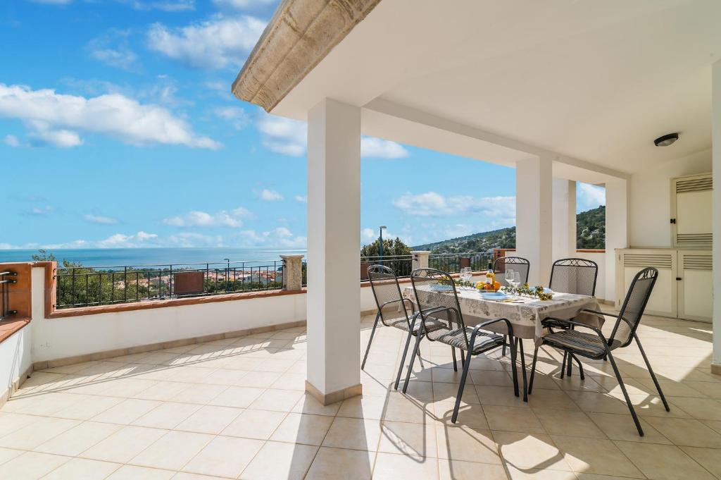 un tavolo e sedie su un balcone con vista sull'oceano di CASA OSALLA 1 a Dorgali