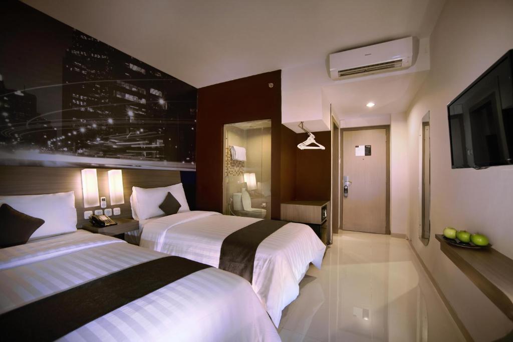 Postel nebo postele na pokoji v ubytování Hotel Neo Candi Simpang Lima - Semarang by ASTON