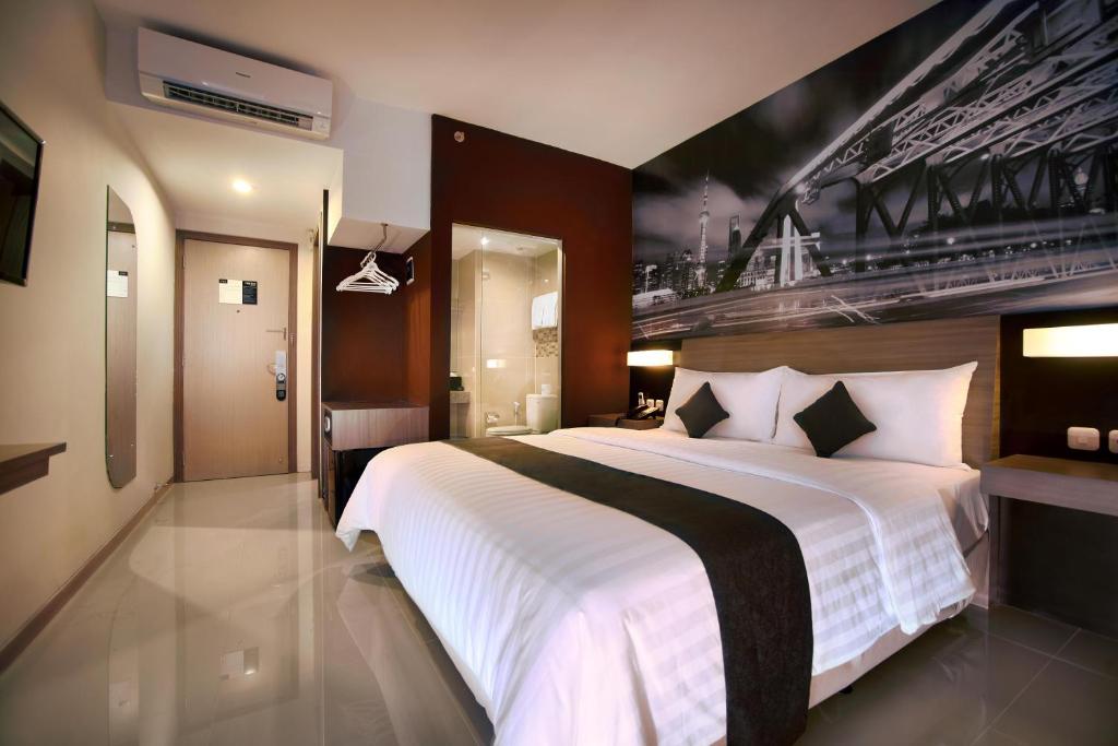 Postel nebo postele na pokoji v ubytování Hotel Neo Candi Simpang Lima - Semarang by ASTON