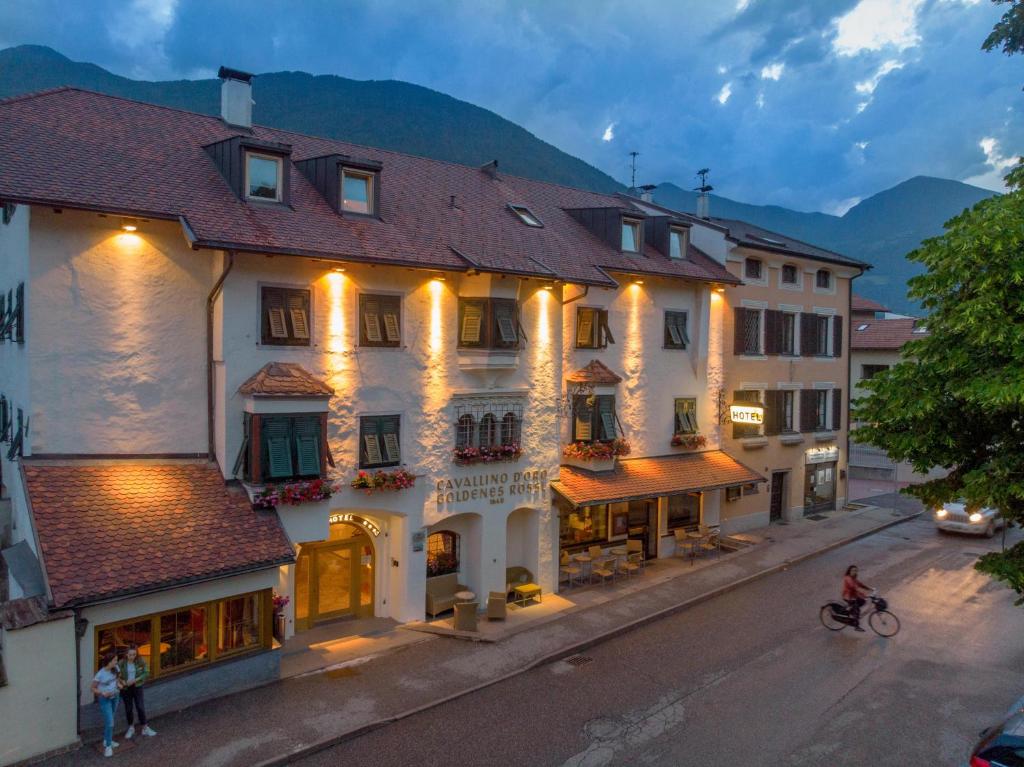 a building with lights on it on a street at Hotel Goldenes Roessl-adults only in Bressanone