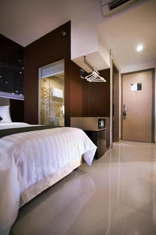 Postel nebo postele na pokoji v ubytování Hotel Neo Candi Simpang Lima - Semarang by ASTON
