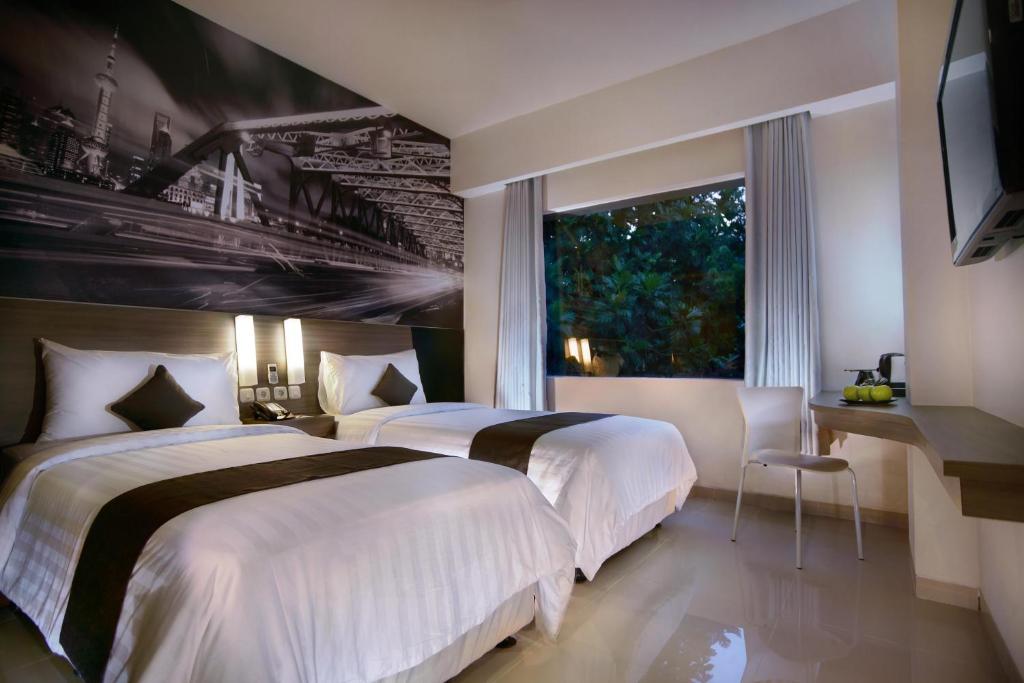 Postel nebo postele na pokoji v ubytování Hotel Neo Candi Simpang Lima - Semarang by ASTON