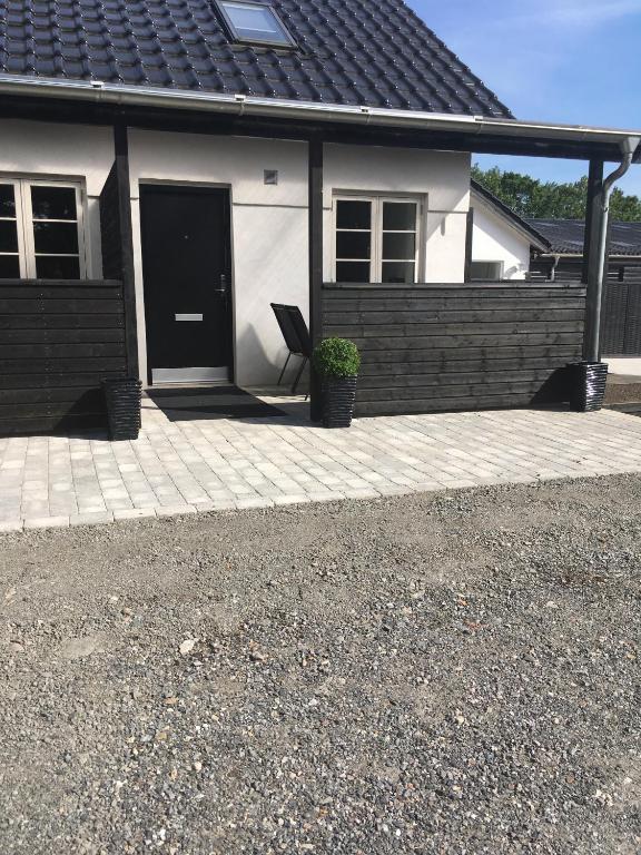 吉弗Hedegaard Holiday Apartments的白色的房子,有黑色的门和椅子