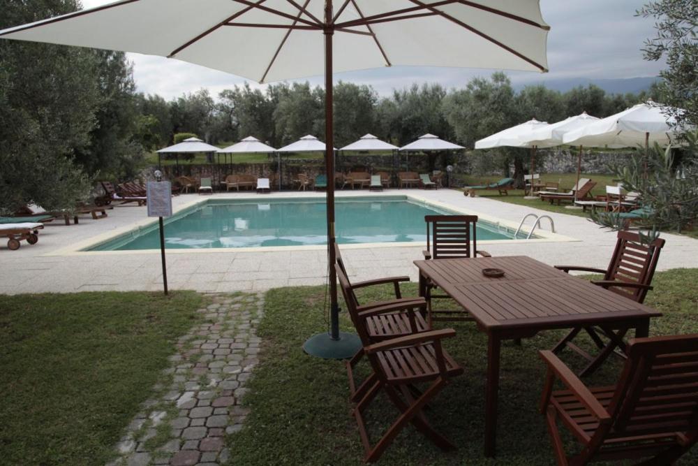 a table with an umbrella next to a swimming pool at Chalet 4 Agriturismo in Tocco da Casauria