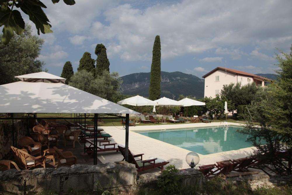 - une piscine avec des chaises et des parasols à côté d'un bâtiment dans l'établissement Dante/Pino, à Tocco da Casauria