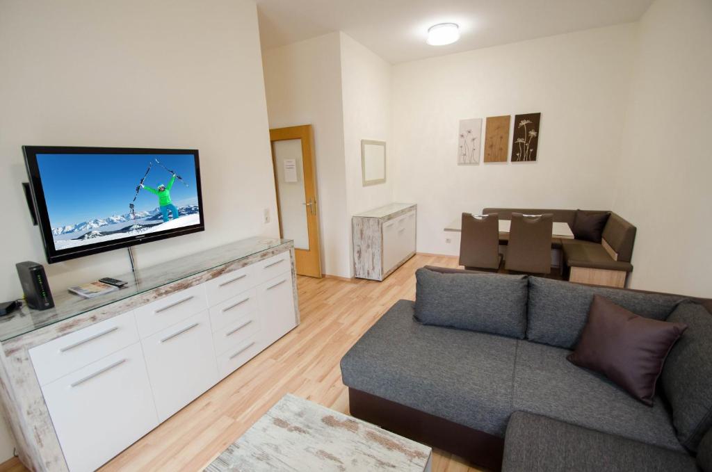ein Wohnzimmer mit einem Sofa und einem Flachbild-TV in der Unterkunft Apartment CityXpress TOP 7 in Zell am See