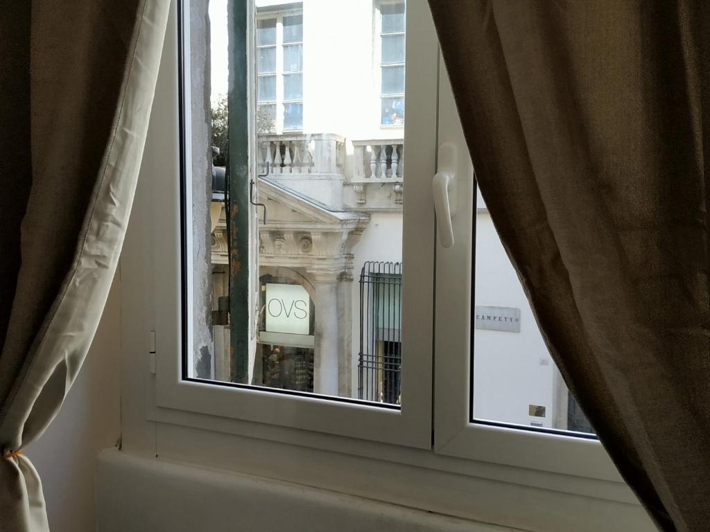 une fenêtre avec vue sur un bâtiment dans l'établissement Center House, à Gênes