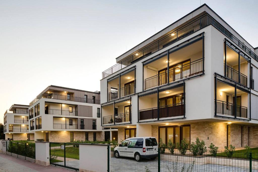 biały van zaparkowany przed budynkiem w obiekcie Balaton Exclusive Apartman w mieście Csopak