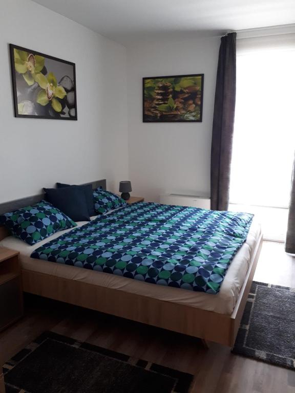 sypialnia z łóżkiem z niebieską kołdrą w obiekcie Balaton Exclusive Apartman w mieście Csopak