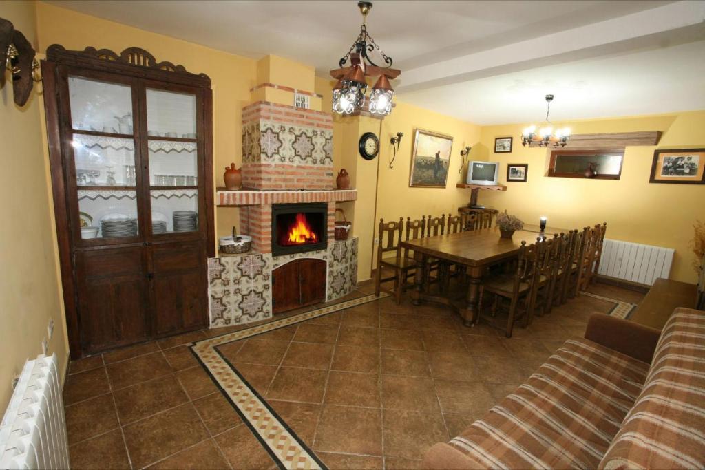 a living room with a table and a fireplace at Casa Rural Calderón de Medina l, ll y lll in Siete Iglesias de Trabancos