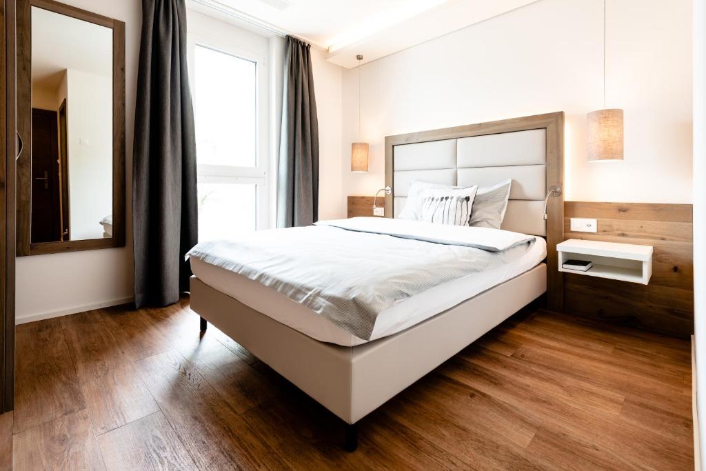 a bedroom with a large bed and a large window at Hotel Rubus in Effretikon