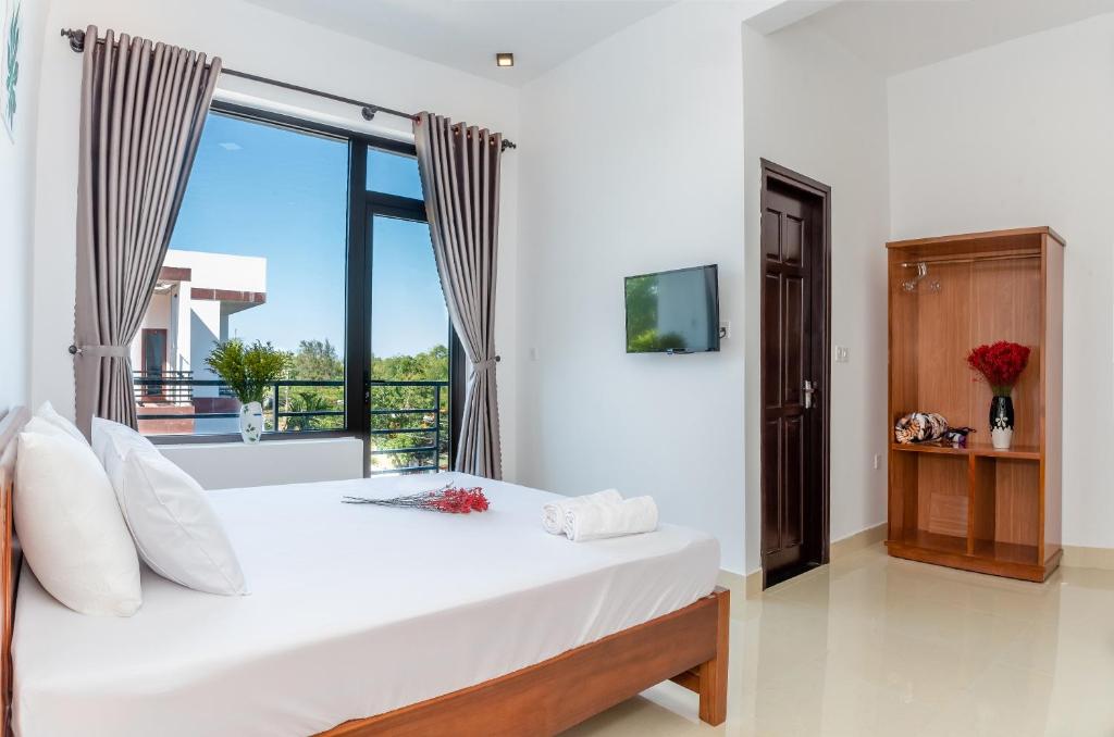 a bedroom with a bed and a large window at PaPa Villa Homestay in Hoi An