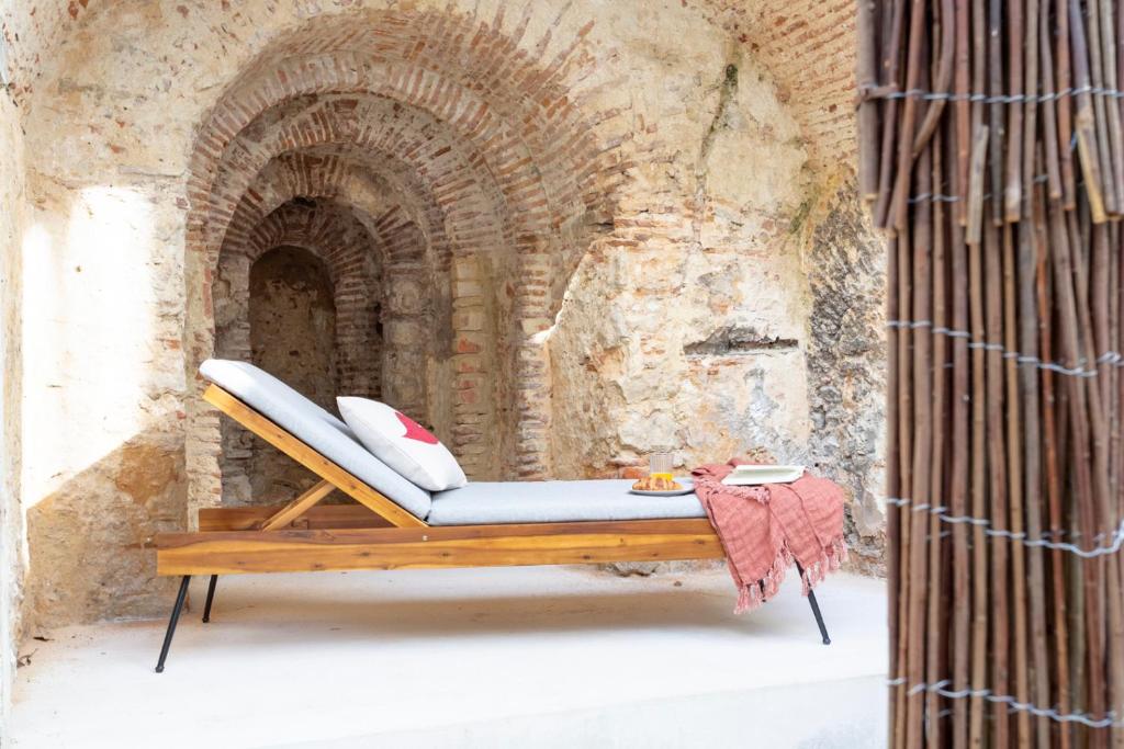 a bench sitting in front of a brick wall at Archi-Pelago Alfama Design Suites Guesthouse in Lisbon