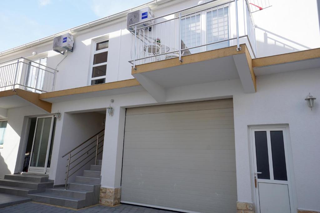 a white house with a garage and a balcony at Apartments Sanja in Jezera