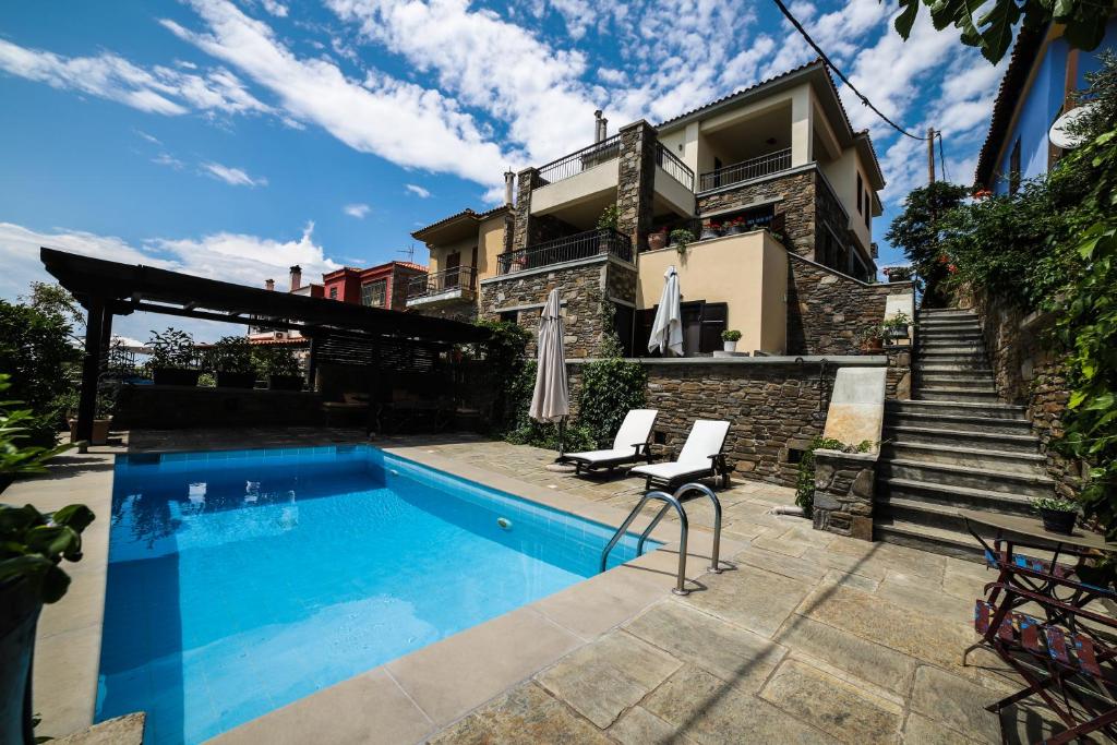 uma casa com piscina ao lado de um edifício em Thea Studios em Partenon