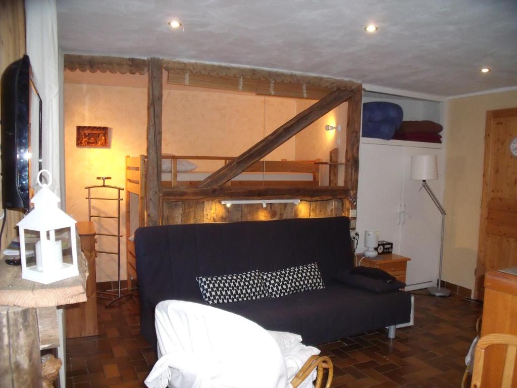 - un salon avec un canapé et des lits superposés dans l'établissement studio a proximite des pistes, à Saint-Chaffrey
