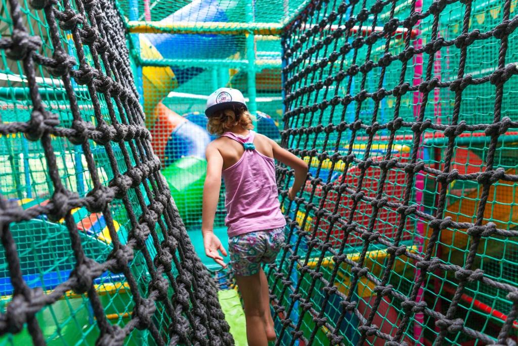 a young girl standing in front of a net at HH van Craenwick Appartement in De Hutte