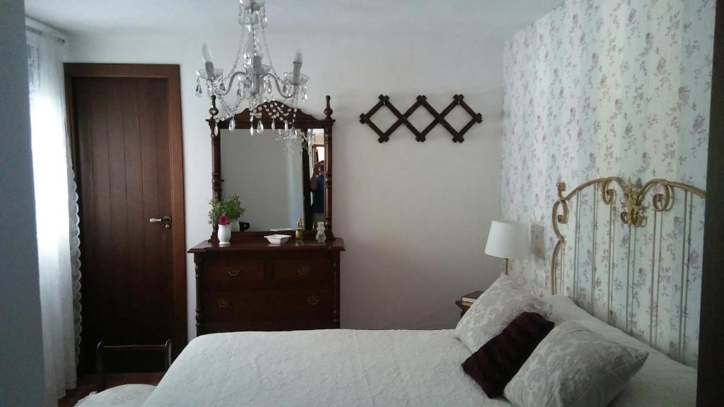 um quarto com uma cama, uma cómoda e um espelho em María em Cortegana