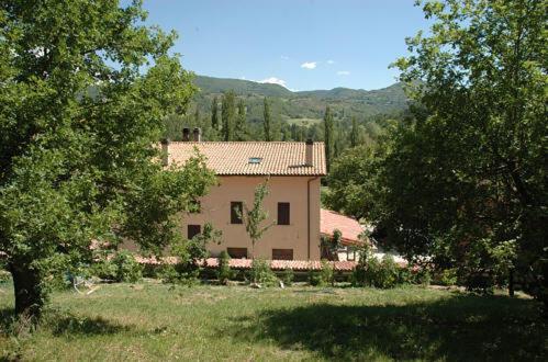 uma casa no meio de um campo com árvores em Agriturismo Monti Sibillini Camperato em Preci