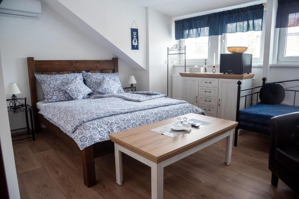 a bedroom with a bed and a coffee table at Penzion a restaurace U Kalendů in Strážnice