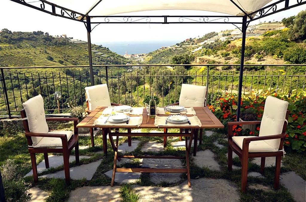 a wooden table and chairs with a view of the ocean at L'angolo del Mare in Pompeiana