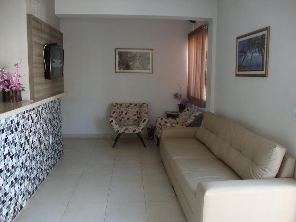 a living room with a couch and a chair at D'arc Hotel in Goiânia