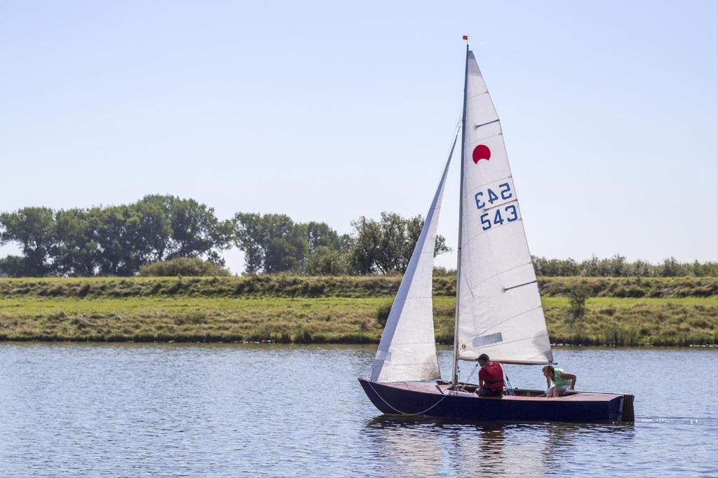 Un par de personas en un velero en el agua en MB Zeeuwse Mobile Home, en Hoek