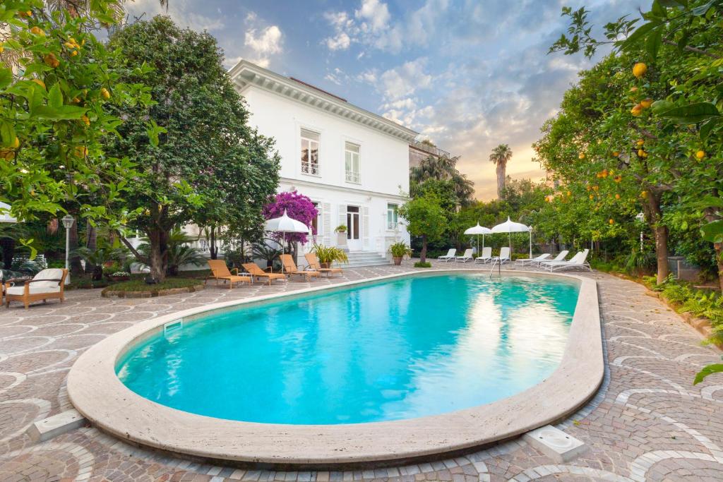 uma piscina em frente a uma casa branca em Relais Villa Savarese em Sant'Agnello