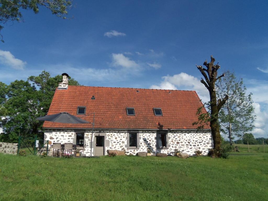 ein großes weißes Steinhaus mit rotem Dach in der Unterkunft Gîte de Bel Air in Anglards-de-Salers