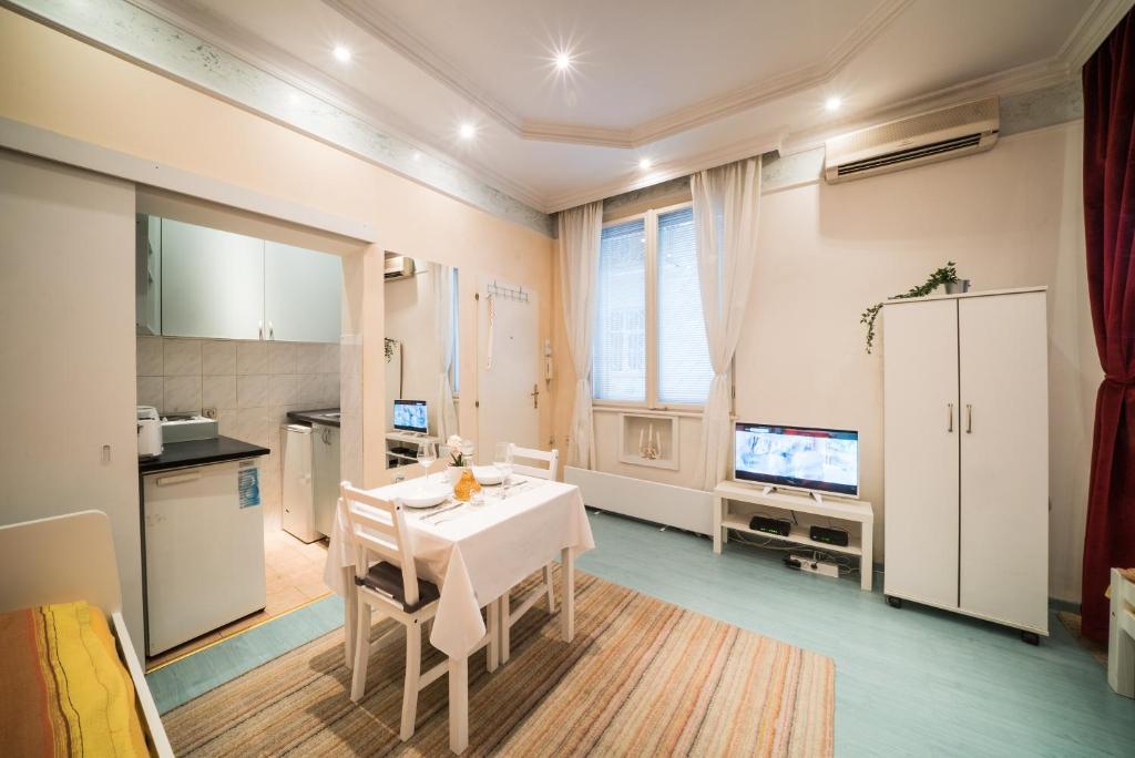 uma cozinha e sala de jantar com uma mesa branca e cadeiras em White Pearl Apartment em Belgrado
