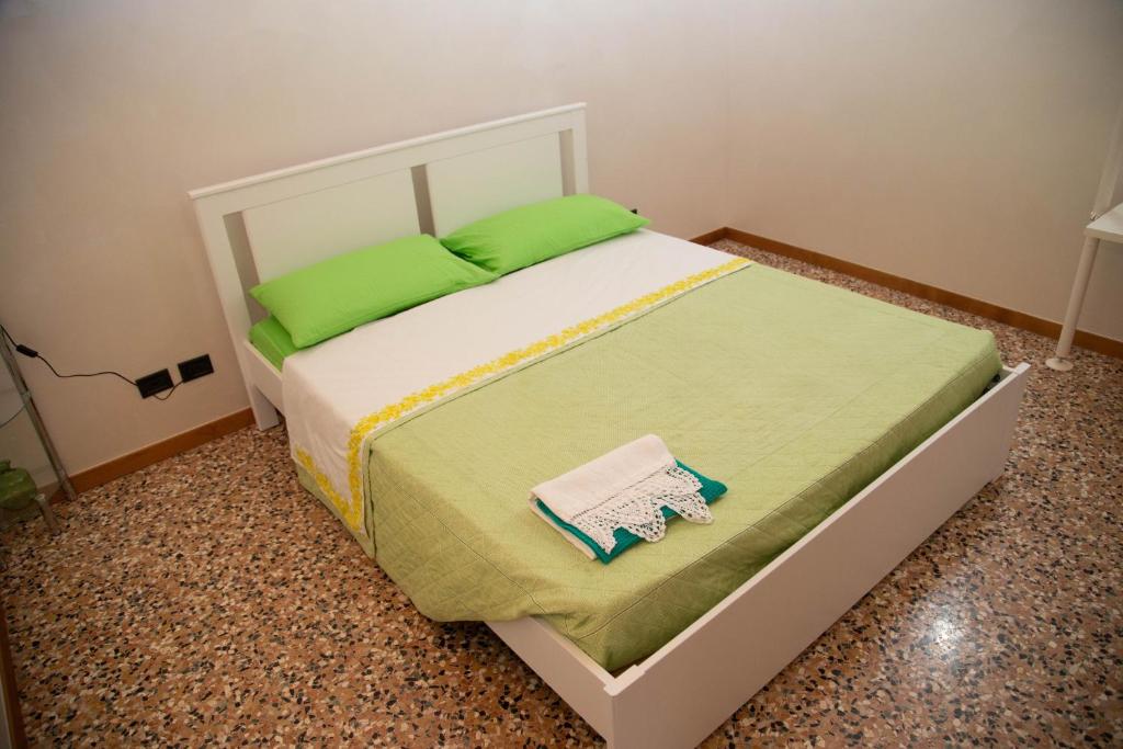 a bedroom with a bed with green pillows on it at Green Apartment in Rosolina Mare