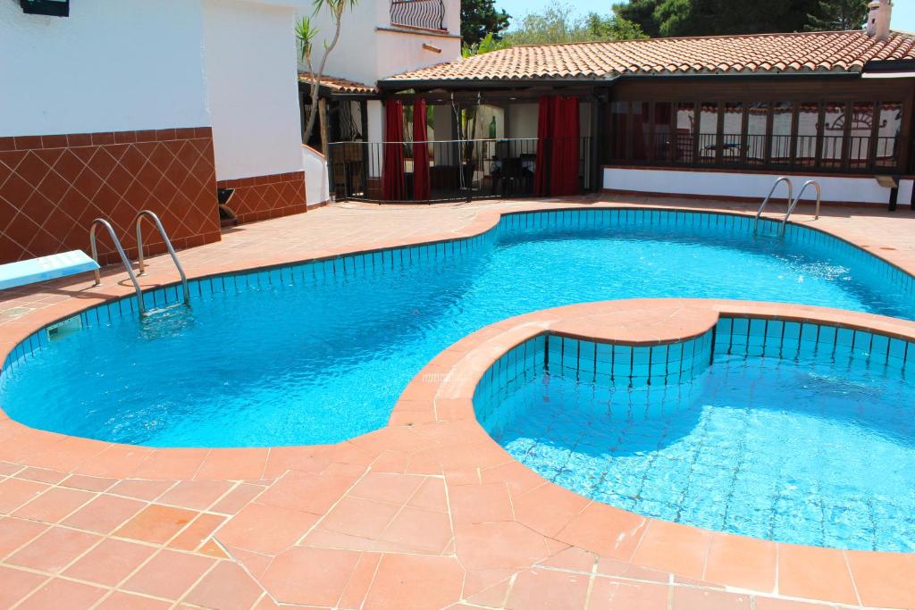 a large blue swimming pool in a yard at Villa Porto Rais in Carini