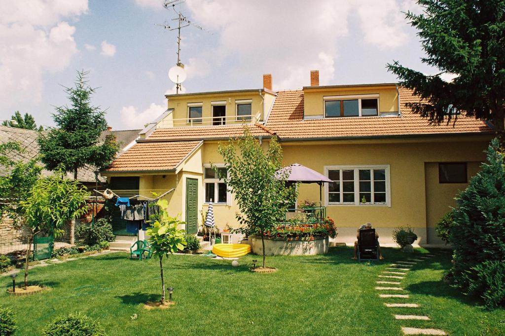 una casa amarilla con un patio con árboles en Apartmán Silvia, en Komárno