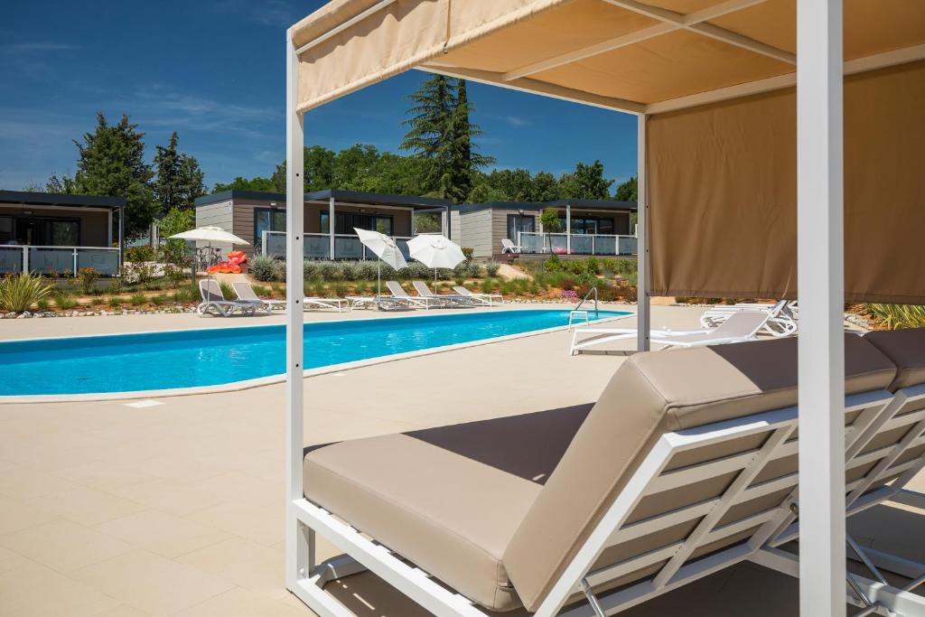 a view of a swimming pool with lounge chairs next to a swimming pool at Mobile Homes Camping Santa Marina, Lanterna in Poreč