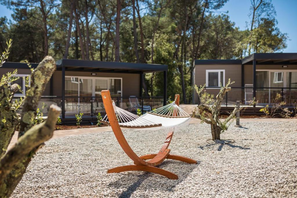 a hammock sitting in front of a house at Mobile Homes Camping Santa Marina, Lanterna in Poreč