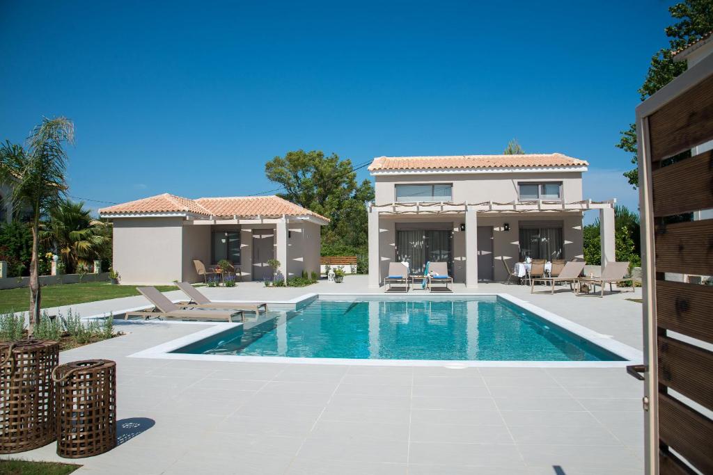 a swimming pool in front of a house at Alba Al Mare Villette in Laganas