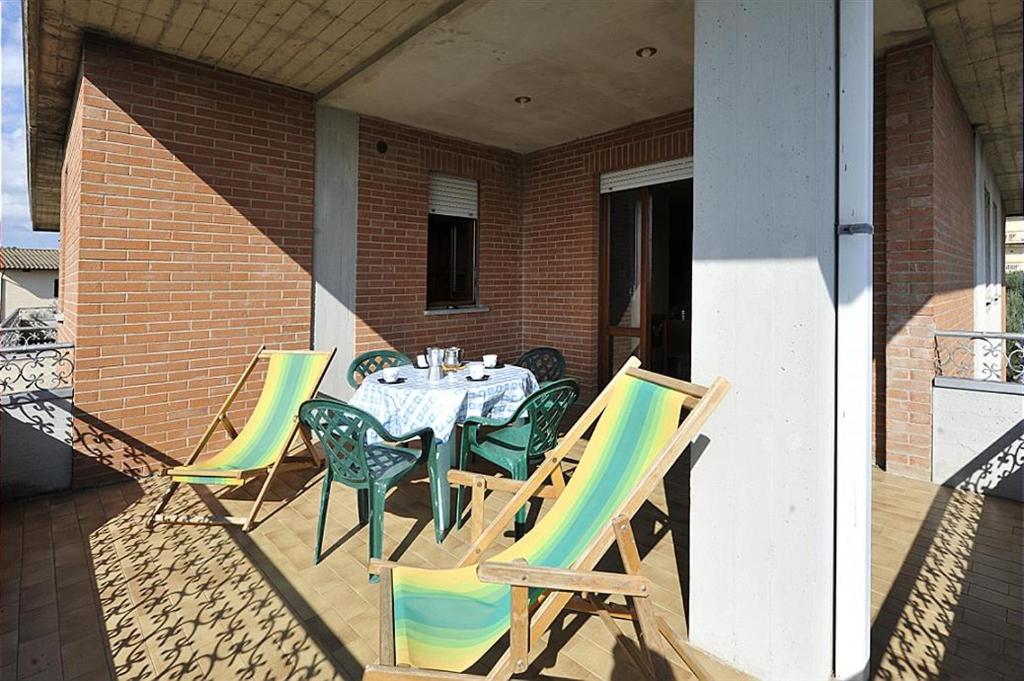une terrasse couverte avec une table et des chaises. dans l'établissement Tommaso 1 Sopra, à Tuoro sul Trasimeno