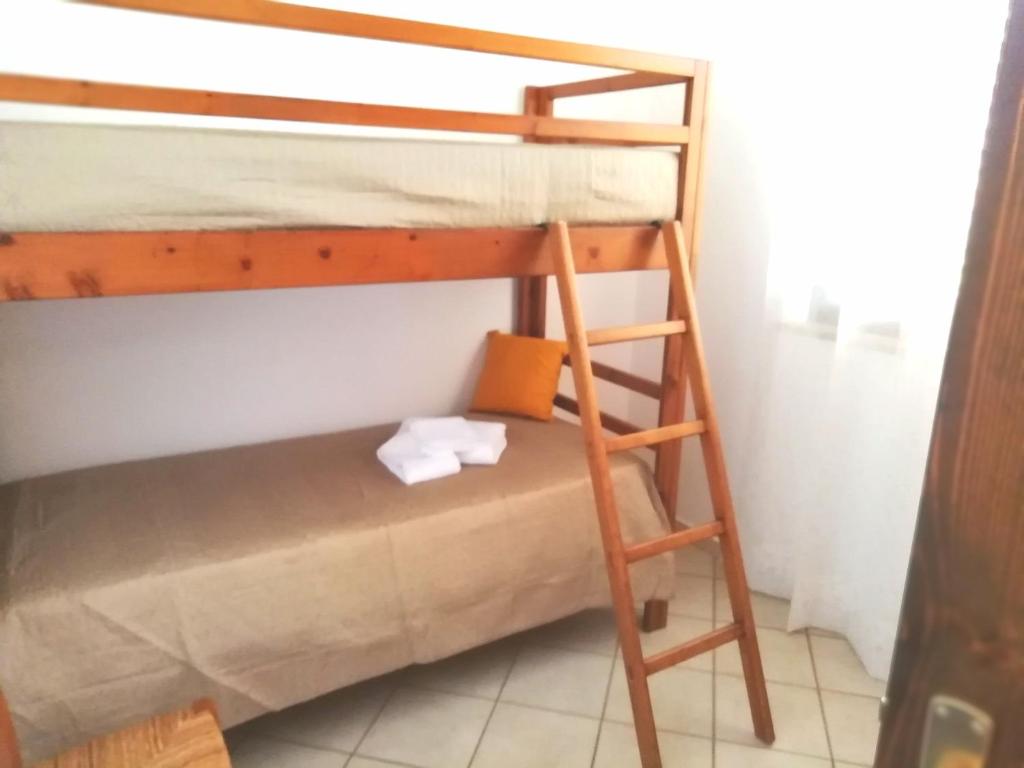 Etagenbett in einem Zimmer mit einer Leiter in der Unterkunft Il Corallo in San Vito lo Capo